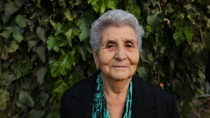 一位老妇人微笑着看着相机的肖像。
