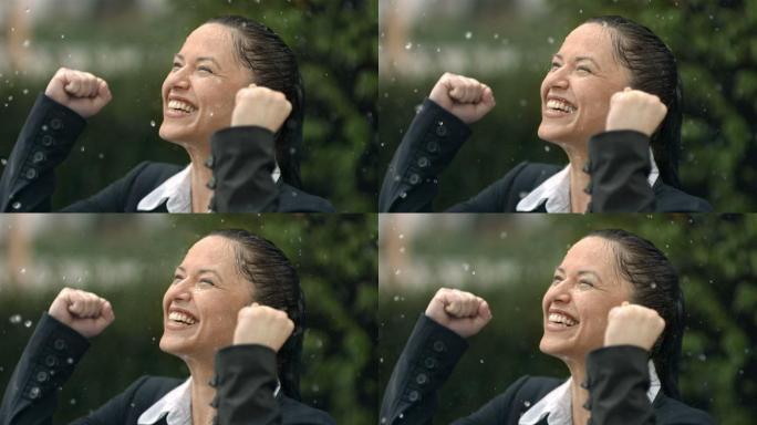 一位中年女商人站在雨中微笑举起双手