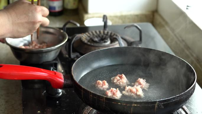 一位中国厨师在滚烫的虾眼水里制作汆肉丸子