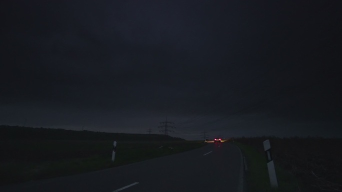 一辆汽车在夜间行驶在乡村公路上