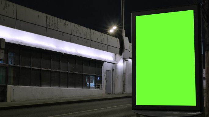 位于繁忙街道上的绿色屏幕广告牌
