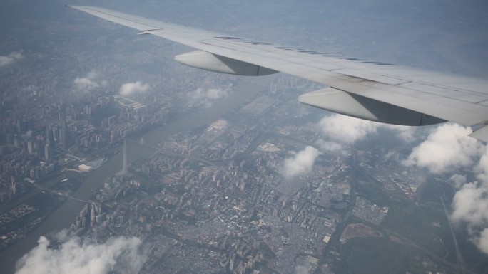 飞机舷窗俯瞰城市上空 在云端 机翼