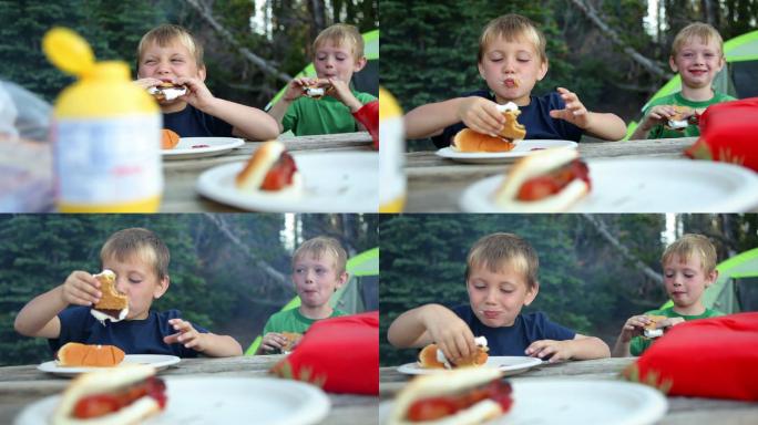 两个小男孩在露营地吃玉米卷