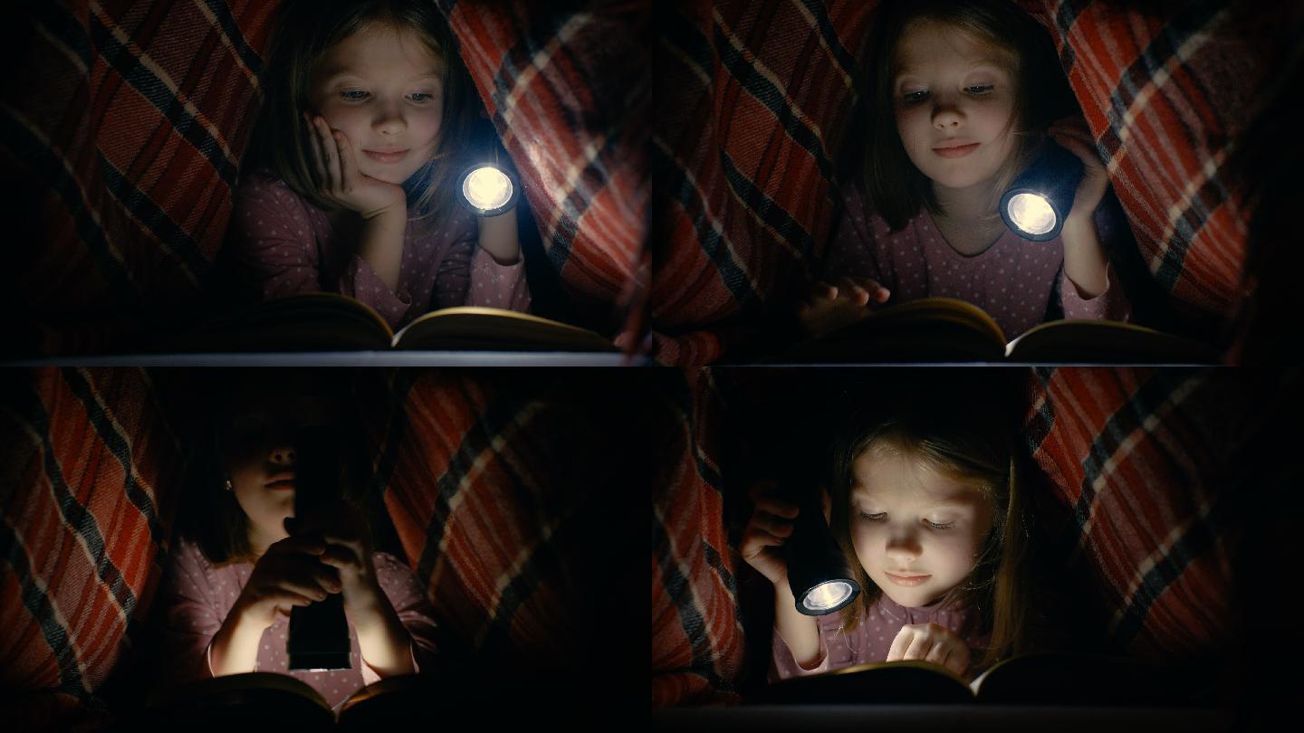 小女孩在毯子下用手电筒读书