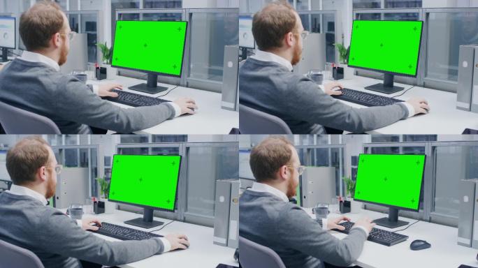 一名上班族在使用绿色模拟屏幕台式电脑