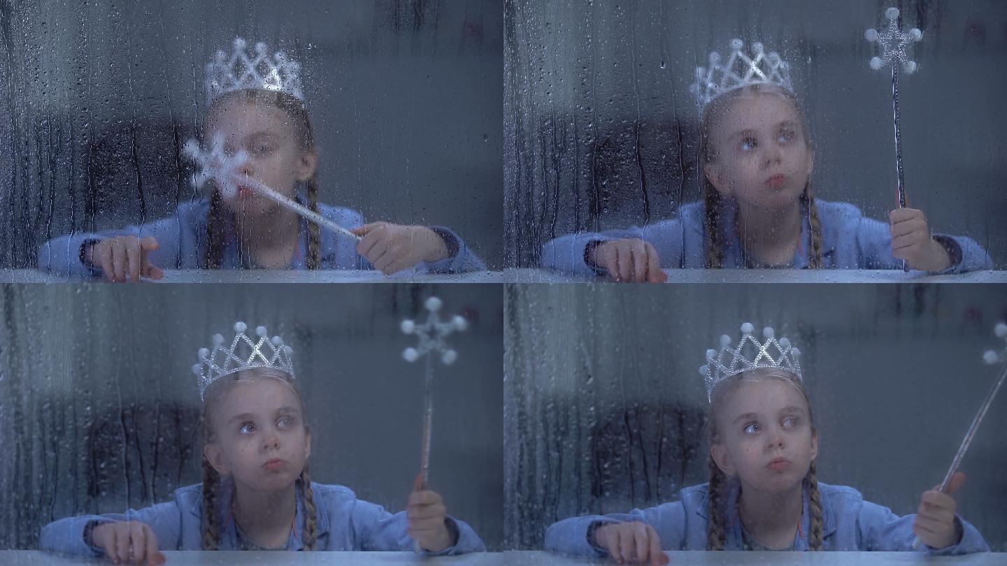 拿着魔杖的小女孩独自坐在雨天的窗户后面