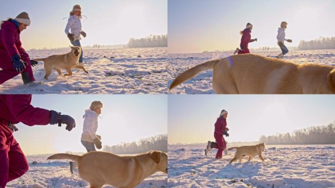 妈妈和女儿在雪地里和狗一起跑