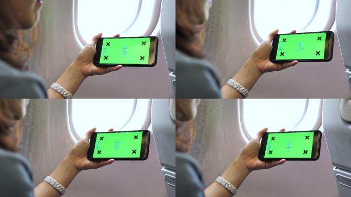 女生在飞机玩带色度键的智能手机