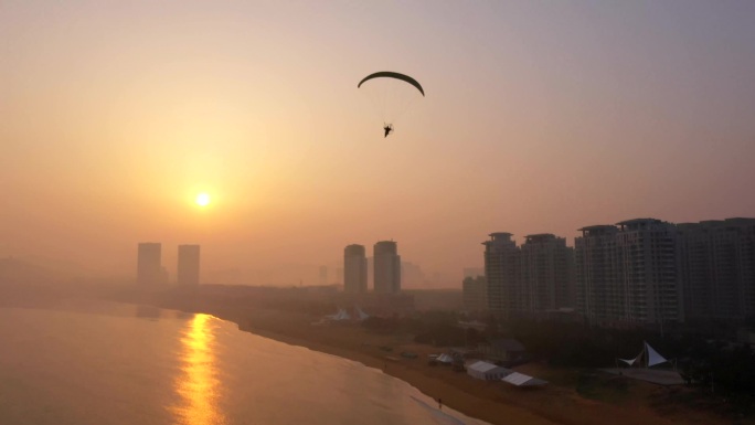 大海早上飞向太阳的滑翔伞