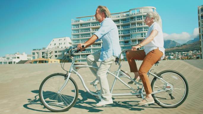 老年夫妇在夏天享受双人自行车的乐趣