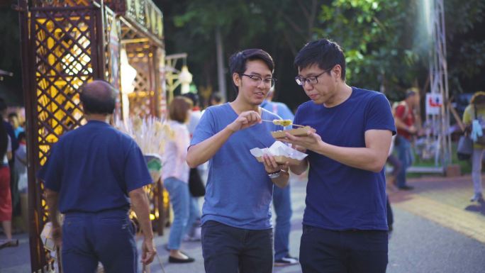 两名男子在泰国传统市场吃饭和交换食物