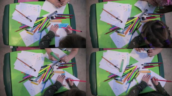 小女孩在幼儿园的教室里素描和画画