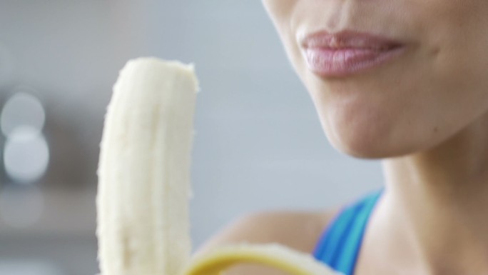 年轻女士微笑着吃香蕉。