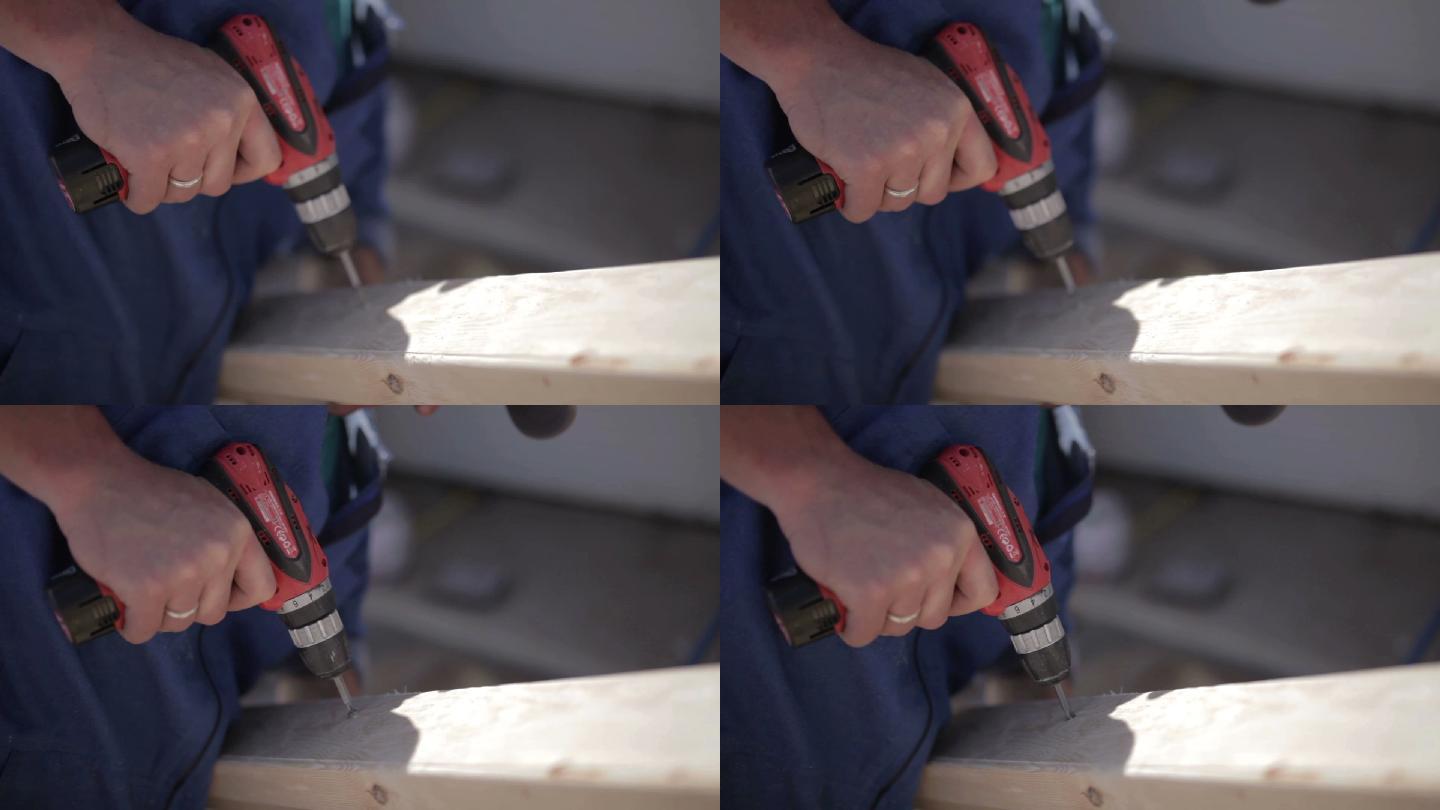 男子在木板上使用电钻、电动螺丝刀