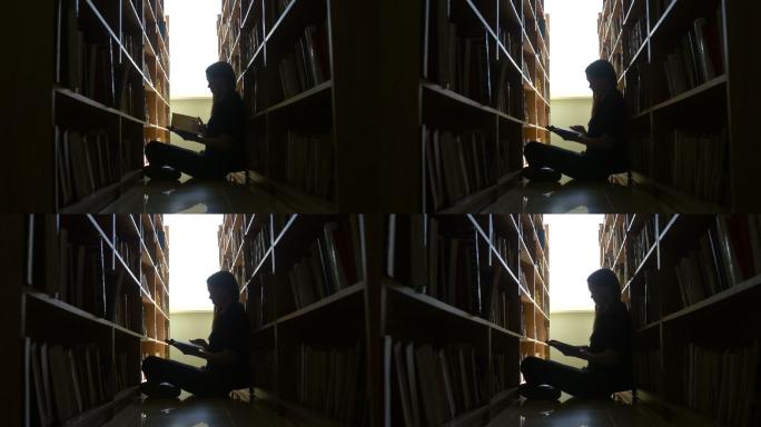 剪影女学生坐在图书馆的地板上