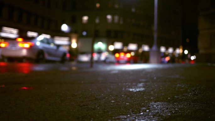 雨夜，城市里的车辆在夜间沿着城市街道行驶