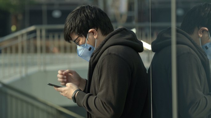 一名男子在空气污染的城市打电话时咳嗽