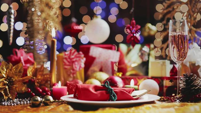 桌上的多莉香槟长笛，盘子，礼物和圣诞装饰。