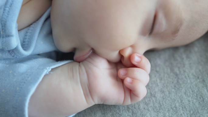 可爱的小男孩含着手指正在睡觉
