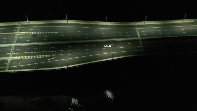 航拍夜晚一辆小车在神冈山大桥上行驶