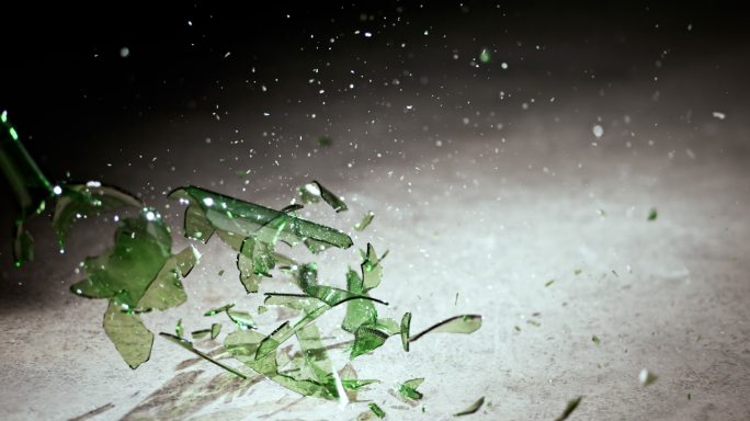 一个绿色瓶子撞在地板上时碎裂