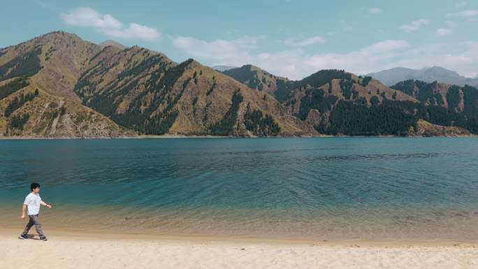 4K新疆天山天池沙滩上行走的人