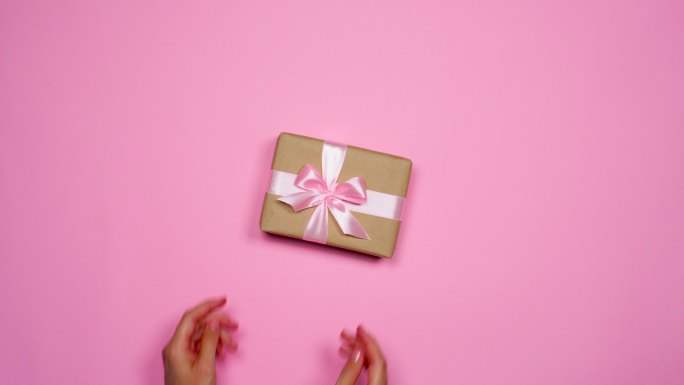 把漂亮的礼品盒放在粉红色桌面上