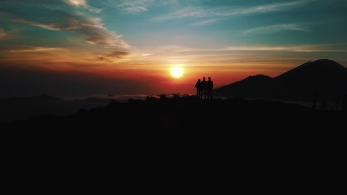 日出时分，人们站在巴厘岛巴图尔火山的顶部