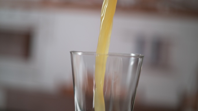 冷橙汁倒进玻璃杯里。