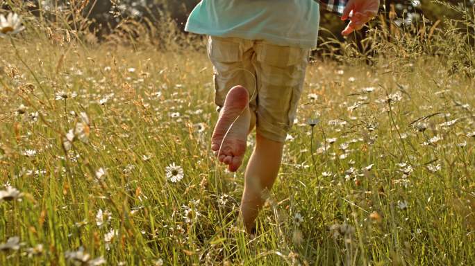 男孩赤脚在草地上奔跑