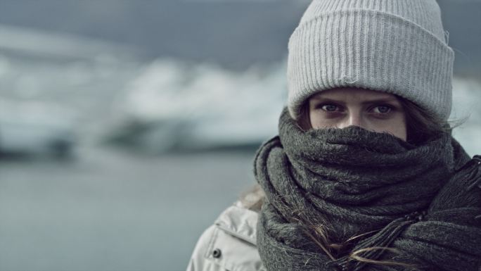 裹着围巾的女人在冰川附近