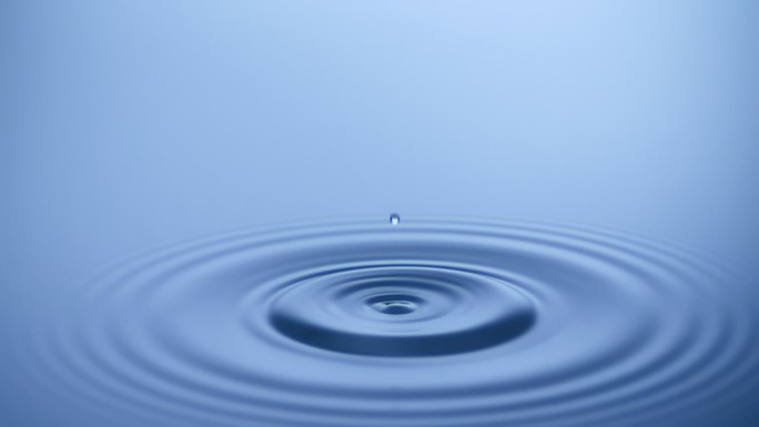 水滴溅入平静的水中-超慢动作