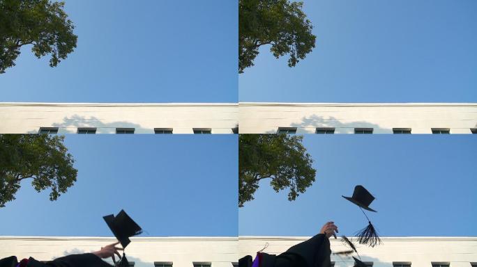 穿着长袍的快乐学生向空中投掷学士帽
