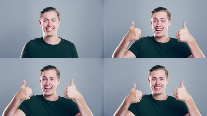 一个年轻人在灰色背景下竖起大拇指