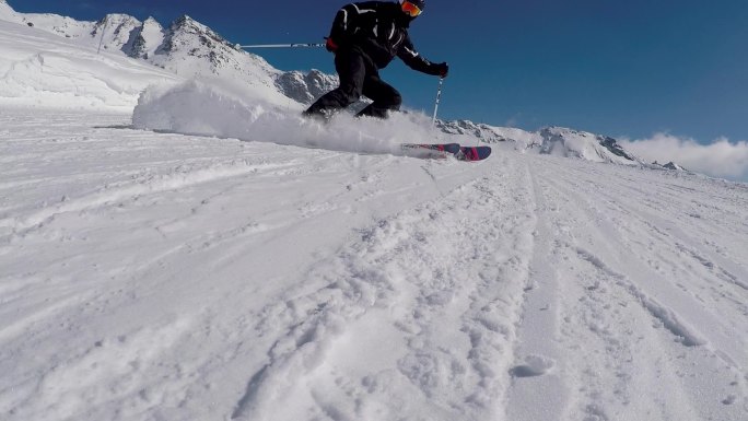 滑雪板在镜头前喷洒雪