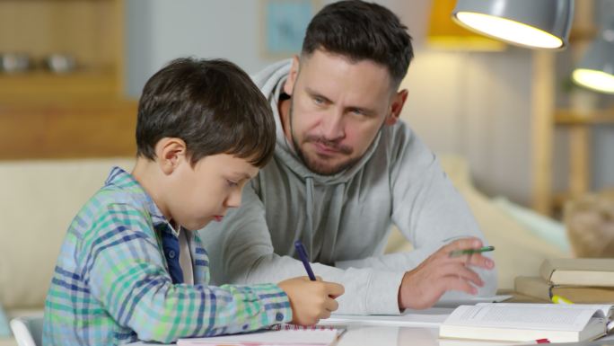 父亲在家里教导儿子做作业