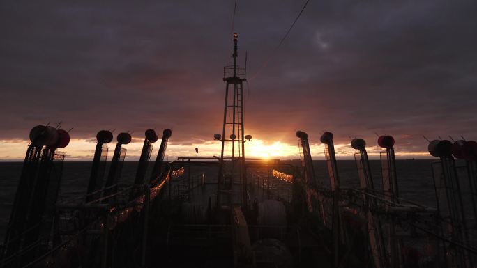 大西洋上迎着落日航行的远洋渔船船头1