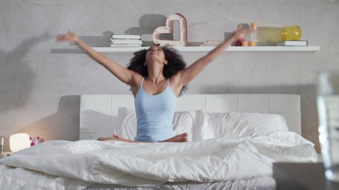 妇女睡后在床上做瑜伽