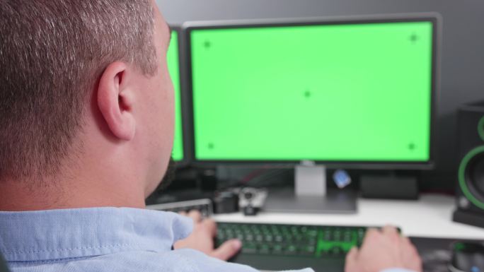 工作人员在绿色屏幕双显示器计算机上工作