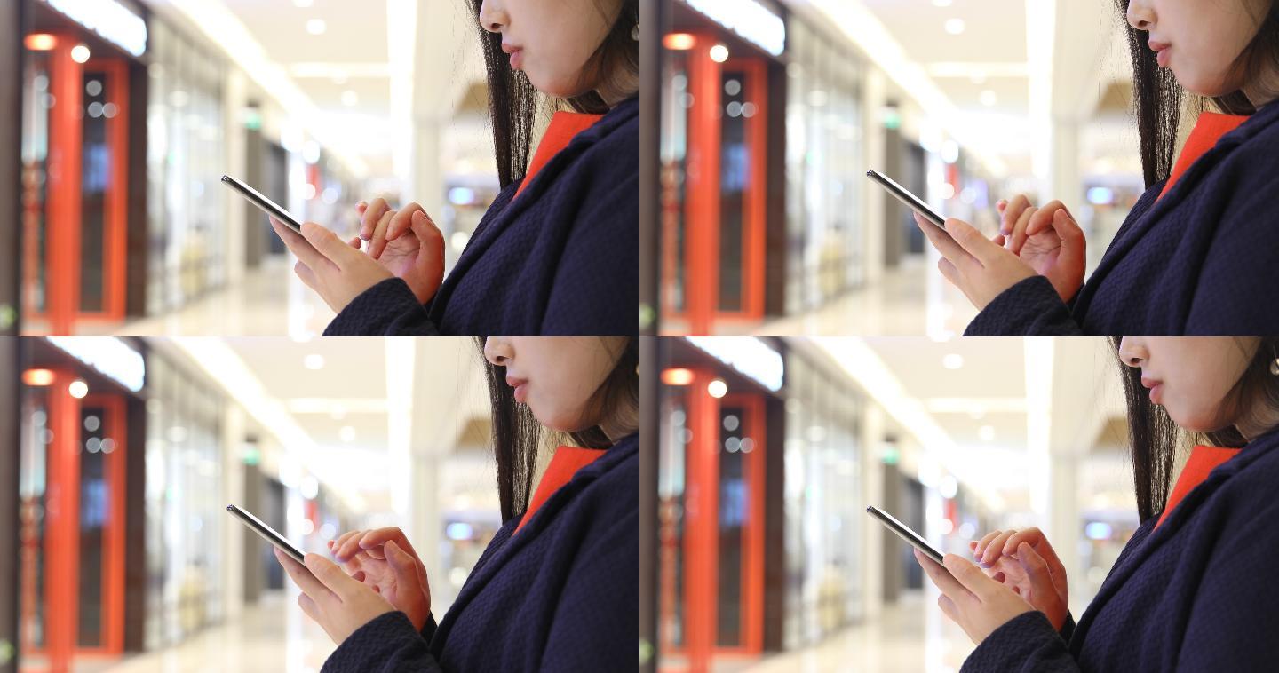 一名女子在商场使用手机