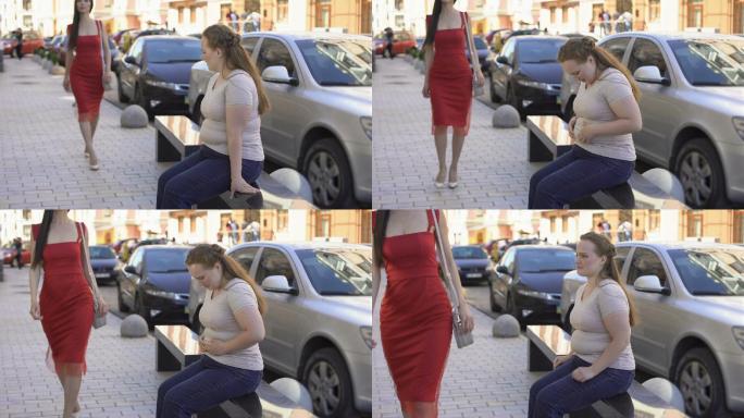 肥胖女性羡慕地看着街上路过的苗条女士