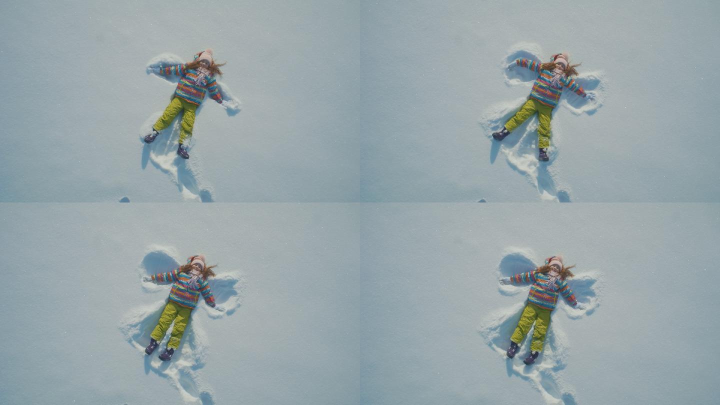 小女孩在雪地里做天使
