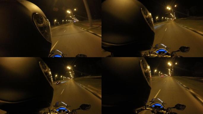 摩托车手在夜间空旷的城市街道上驾驶
