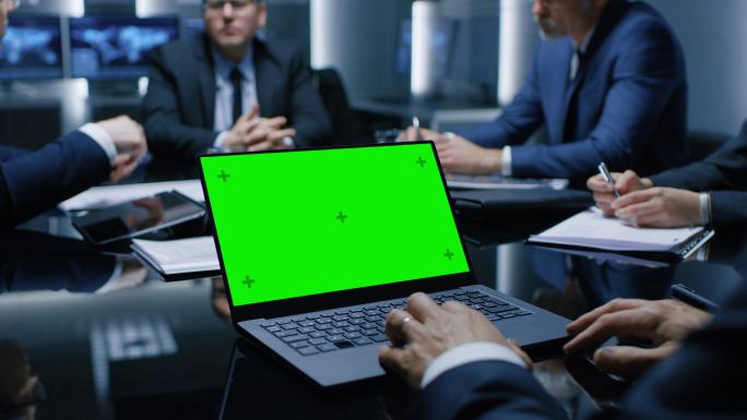 桌上的笔记本电脑上显示着绿色的模拟屏幕
