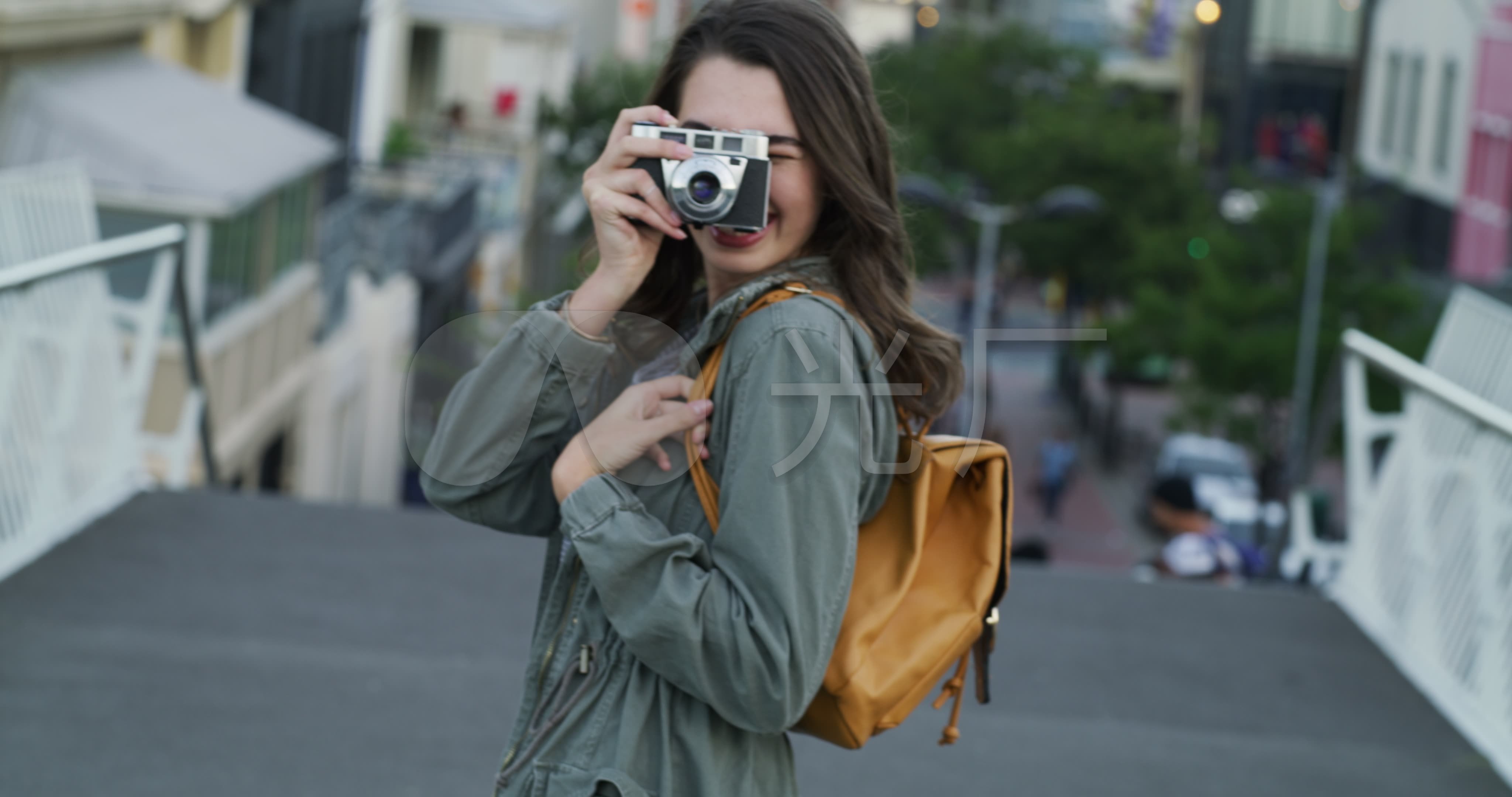 年轻女子拿着照相机回头拍照