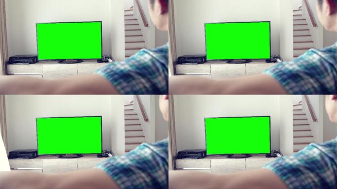 男子在绿色屏幕上看电视