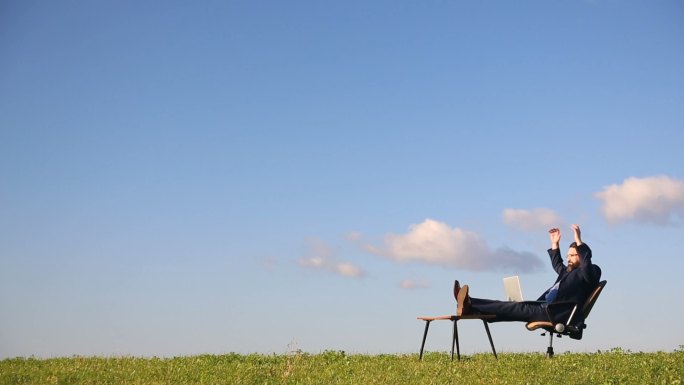 在野外使用笔记本电脑的商人。