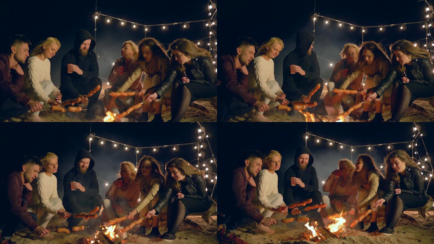 朋友们晚上在沙滩篝火上烧烤