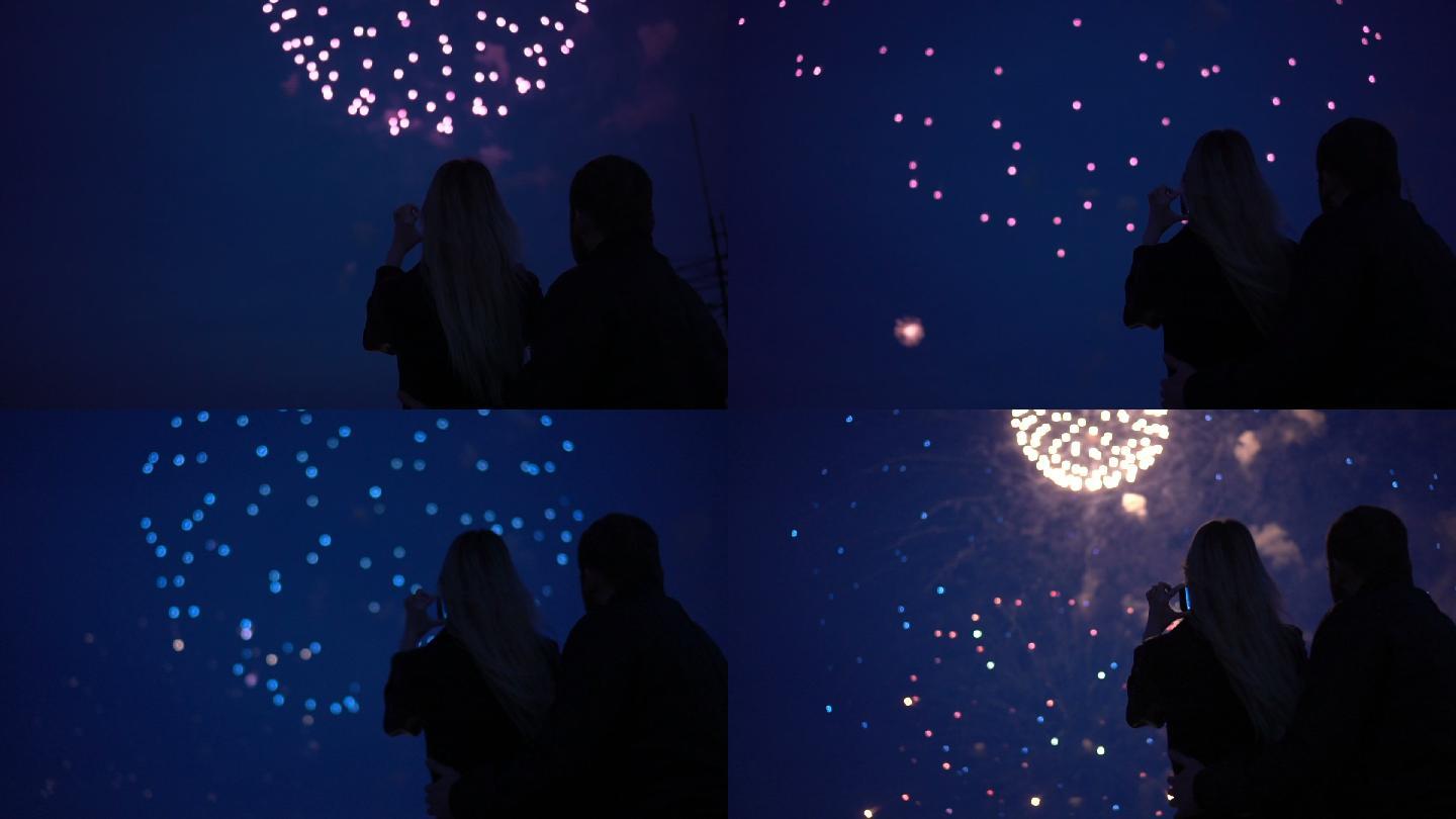 一对相爱的夫妇观看焰火的剪影。