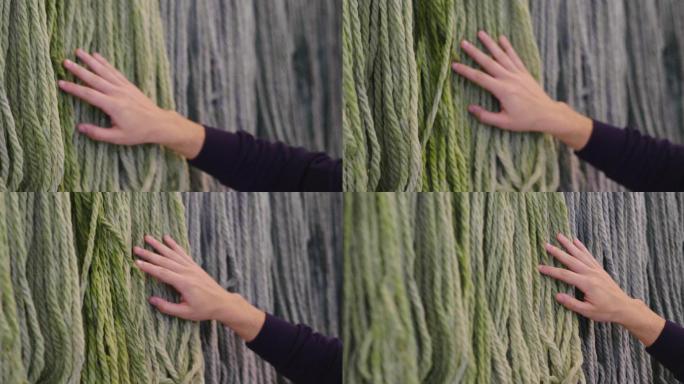 一只手触摸温暖柔软的羊毛的特写镜头。